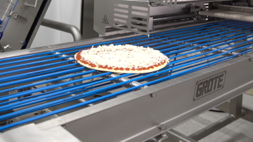 Cheese pizza being manufactured on Grote production line.