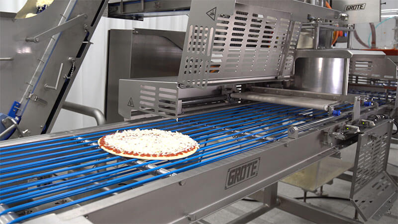 Dogtown Pizza uses a Grote topping applicator to automate its pizza production.