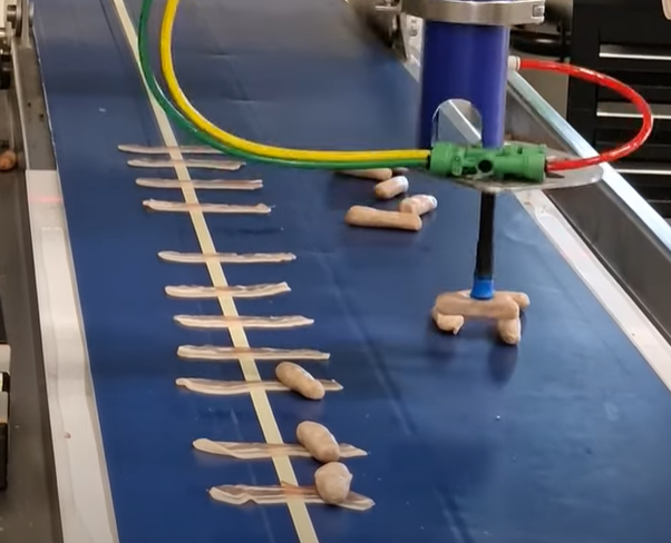 Robotics pick up sausage & place onto bacon in food production line. Robotics pick up sausage & place onto bacon in food production line.